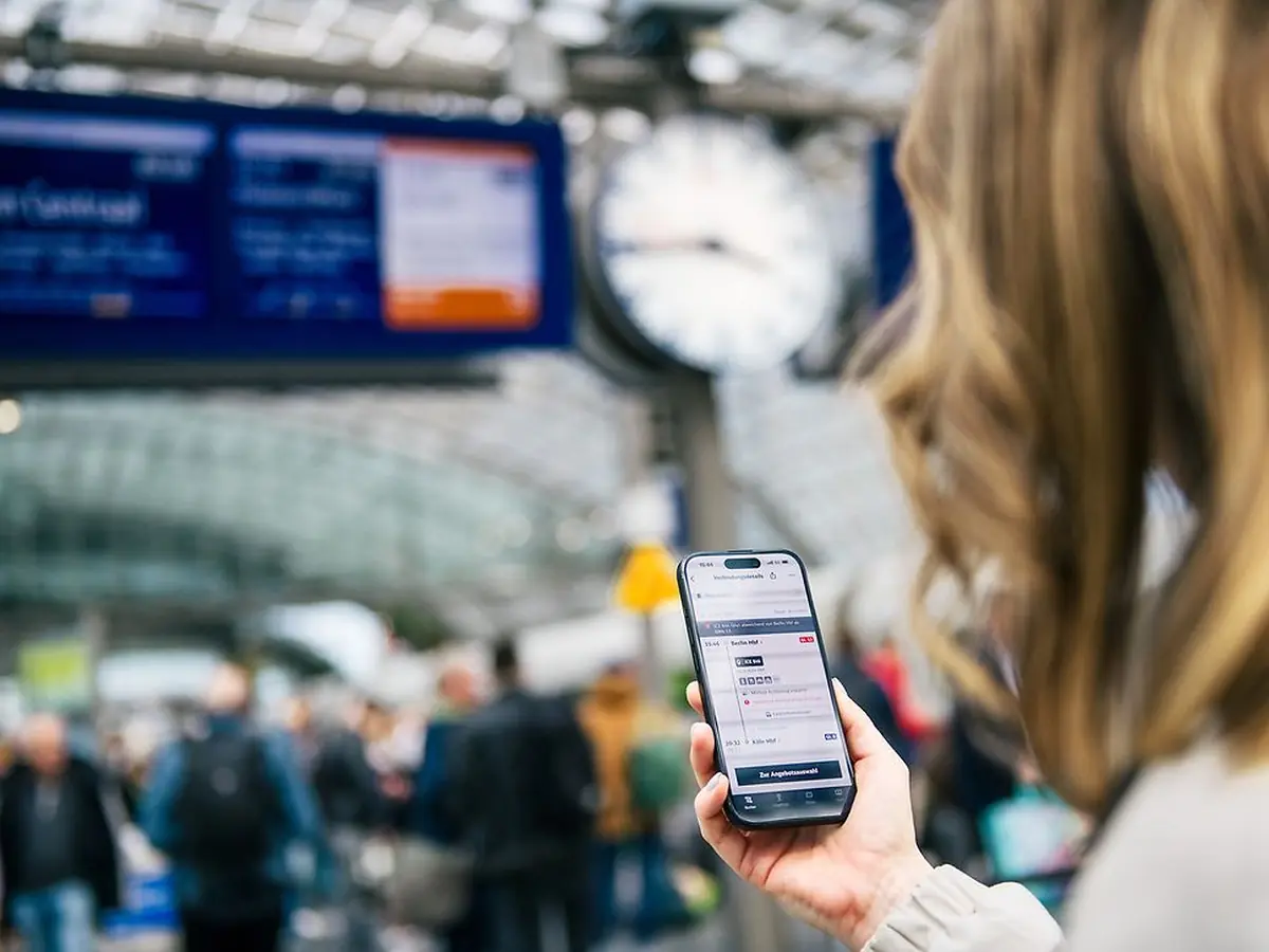 DB Navigator on a station platform Passenger using DB Navigator on a station platform