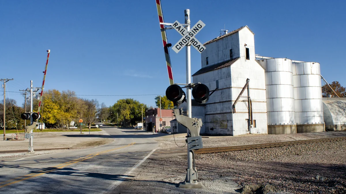Railroad crossing gates beside grain silos in Roca, Nebraska Railroad crossing gates beside grain silos in Roca, Nebraska
