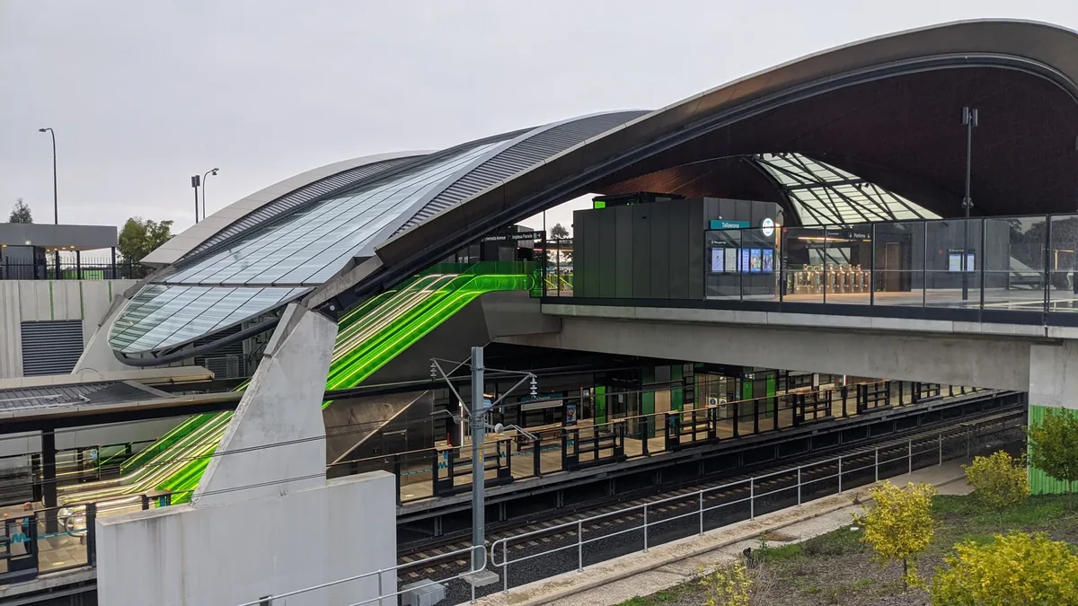 Exterior of Tallawong Metro Station with its curved roof, platforms and illuminated escalators. Exterior of Tallawong Metro Station with its curved roof, platforms and illuminated escalators.