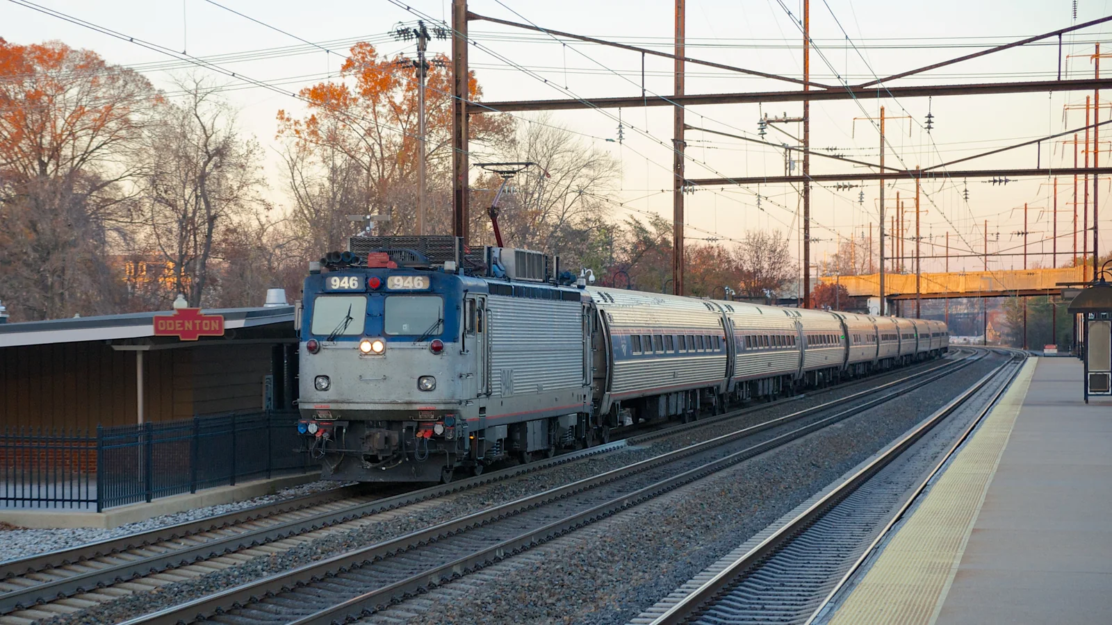 An Amtrak Northeast Regional train running beneath overhead wires at Odenton station.
