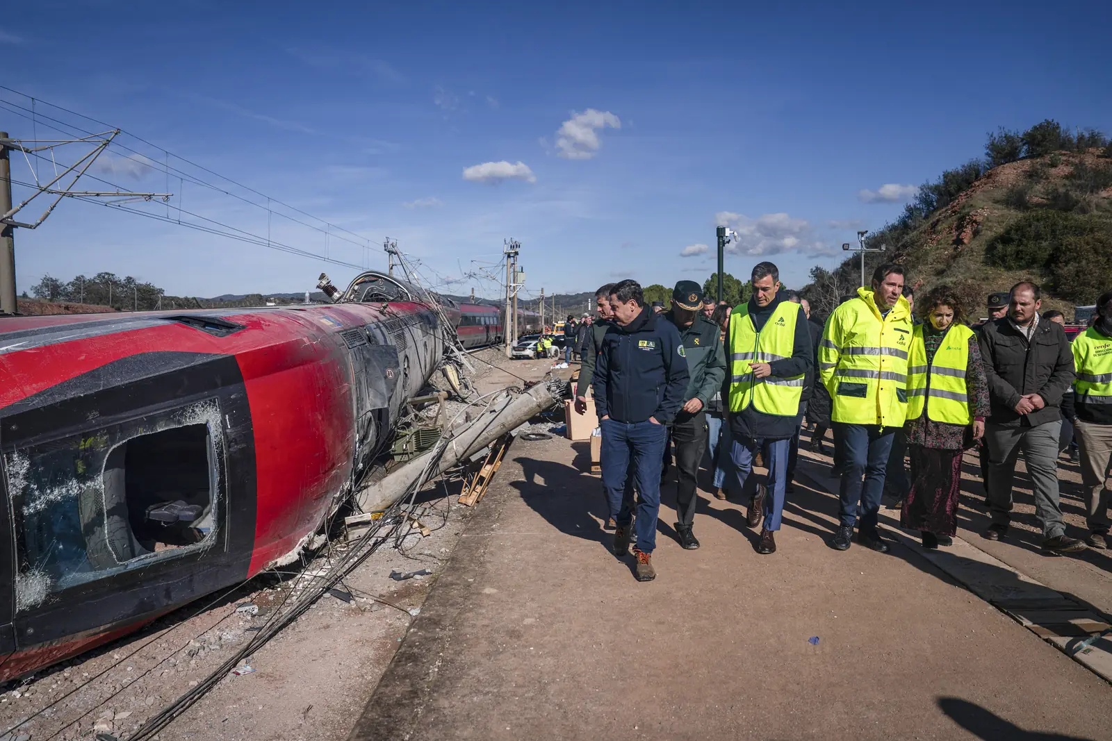 Officials walking beside the derailed Iryo train at the Adamuz accident site.