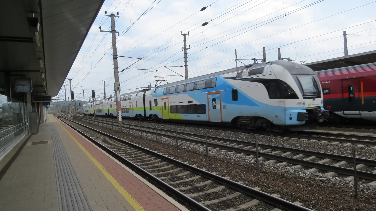 A double-deck Westbahn train passing through St. Valentin station in Austria. A double-deck Westbahn train passing through St. Valentin station in Austria.