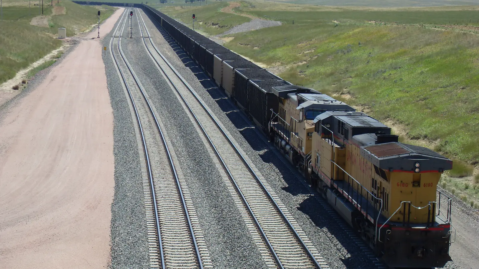 Union Pacific coal train traveling on parallel tracks in Wyoming, shown as an illustrative image