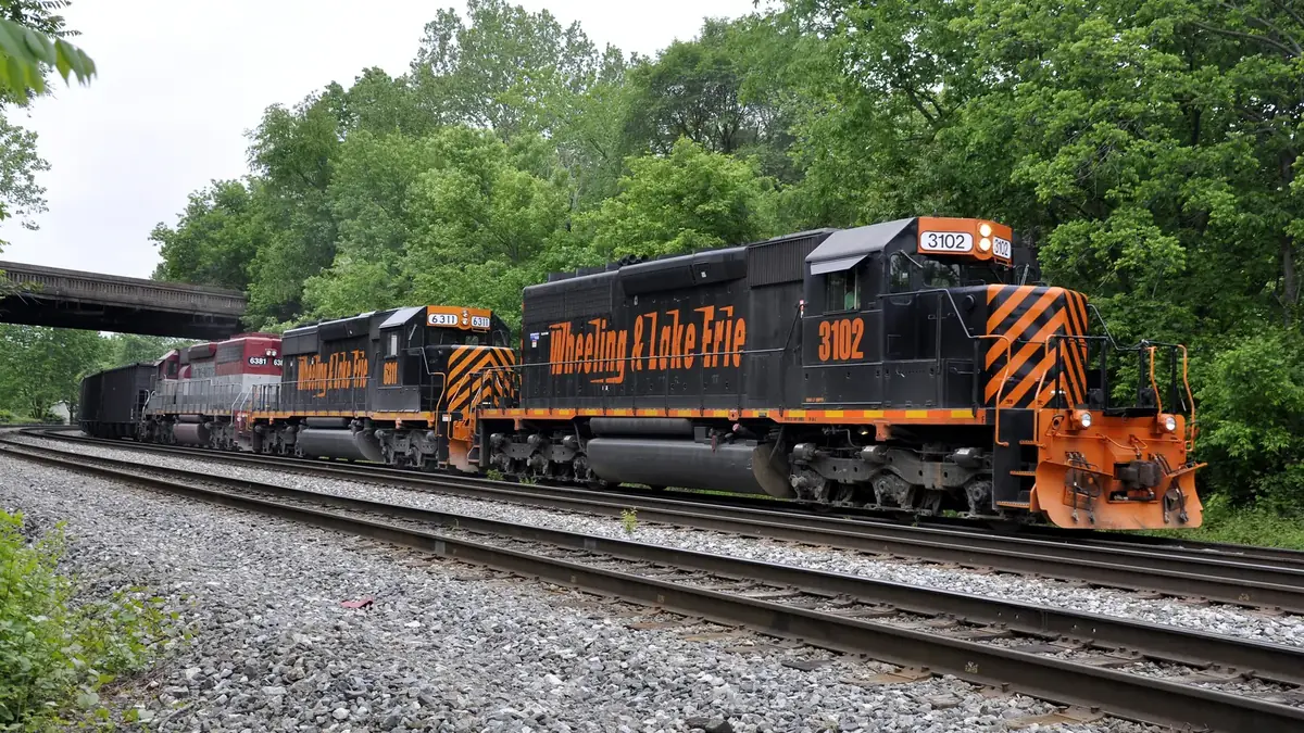 Wheeling & Lake Erie freight locomotives hauling a train on a wooded rail line Wheeling & Lake Erie freight locomotives hauling a train on a wooded rail line