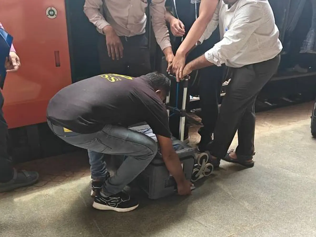 Staff unload the donor heart transport container beside the Vande Bharat Express in Gujarat.