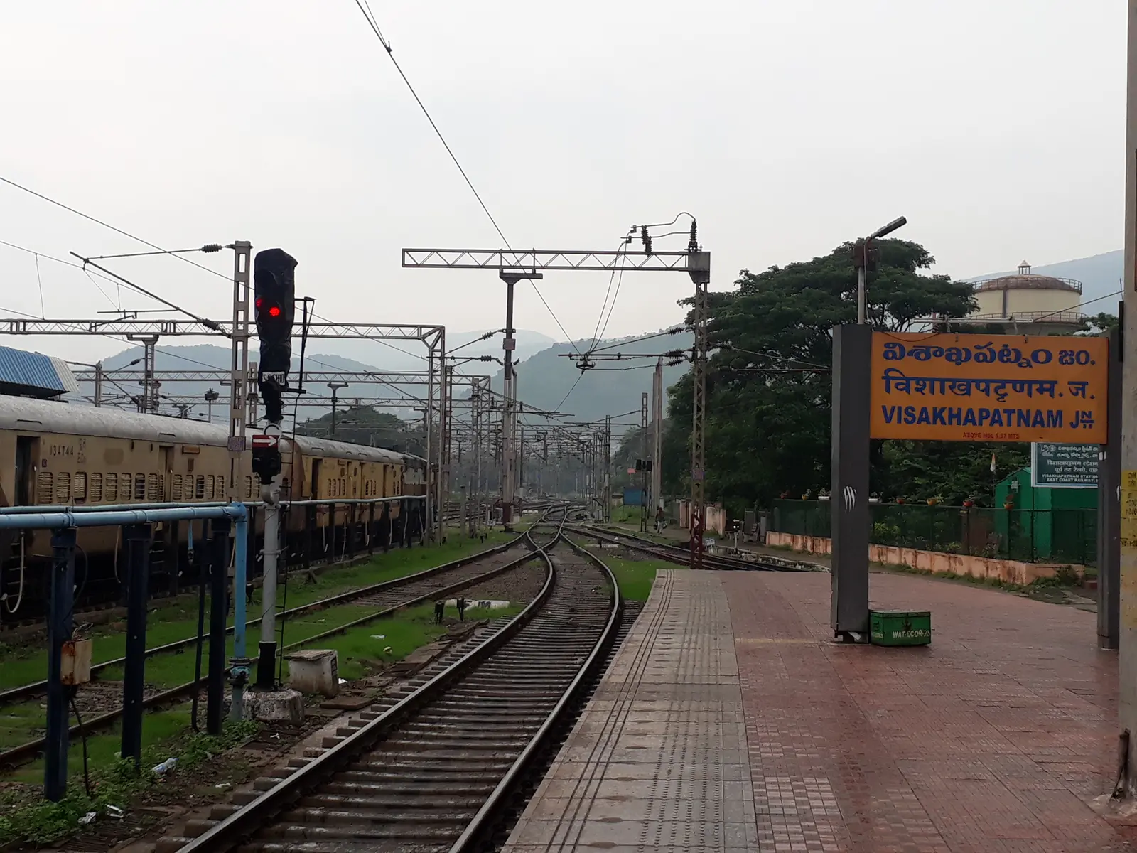 Railway tracks, a signal and a Visakhapatnam Junction station sign Railway tracks, a signal and a Visakhapatnam Junction station sign