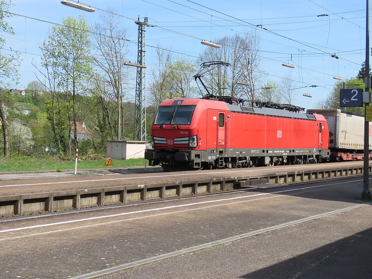 Red DB Cargo locomotive 193 315 hauling a freight train through Solnhofen station in Bavaria Red DB Cargo locomotive 193 315 hauling a freight train through Solnhofen station in Bavaria