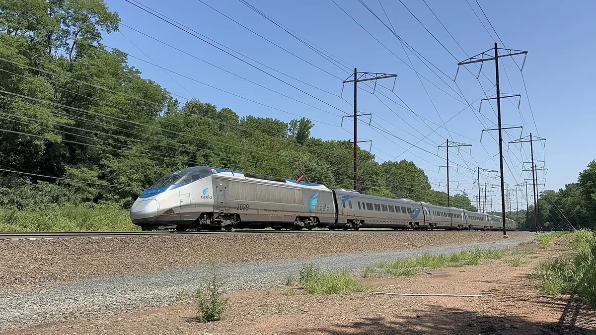 Amtrak Acela train traveling on the electrified Northeast Corridor in New Jersey.