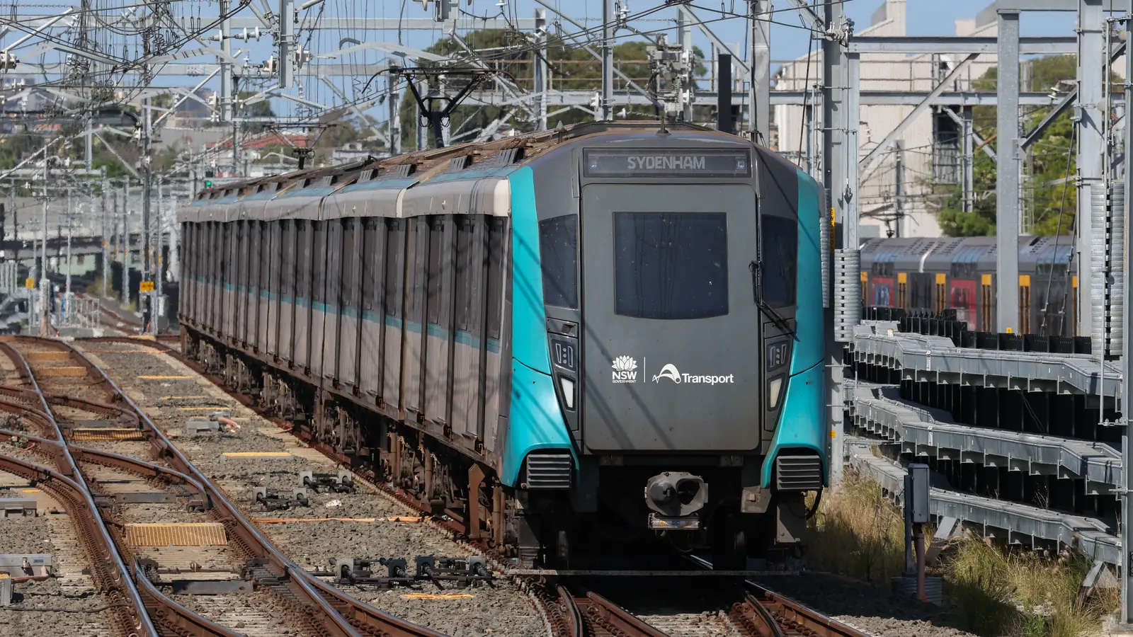 Driverless Sydney Metro train approaching Sydenham station on electrified tracks. Driverless Sydney Metro train approaching Sydenham station on electrified tracks.