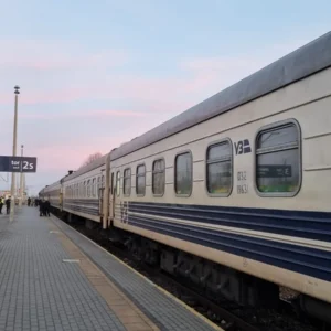 Ukrzaliznytsia passenger cars standing beside a station platform in Chełm