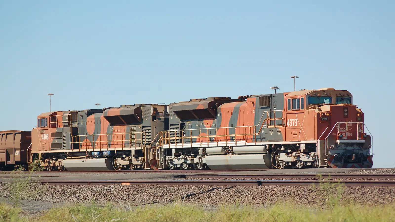 Two BHP iron ore locomotives with ore wagons at Nelson Point Yard in Port Hedland. Two BHP iron ore locomotives with ore wagons at Nelson Point Yard in Port Hedland.