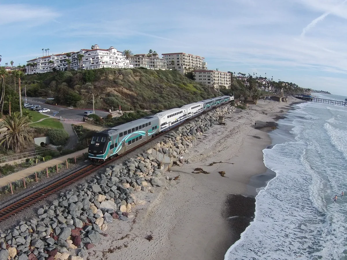 Metrolink train running beside the beach and bluff at San Clemente, California.