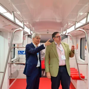 Rail vehicle interior displayed at InnoTrans 2024 with two visitors inside the carriage.