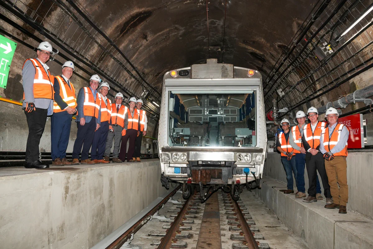 Officials beside a train during Amtrak’s reopening of East River Tunnel Line 2 in New York