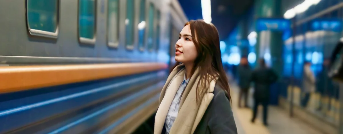 Woman beside a Kazakhstan passenger train used for women-only carriage service