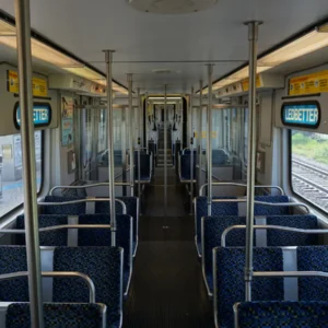 DART light rail vehicle interior with passenger seats, vertical poles and a central aisle