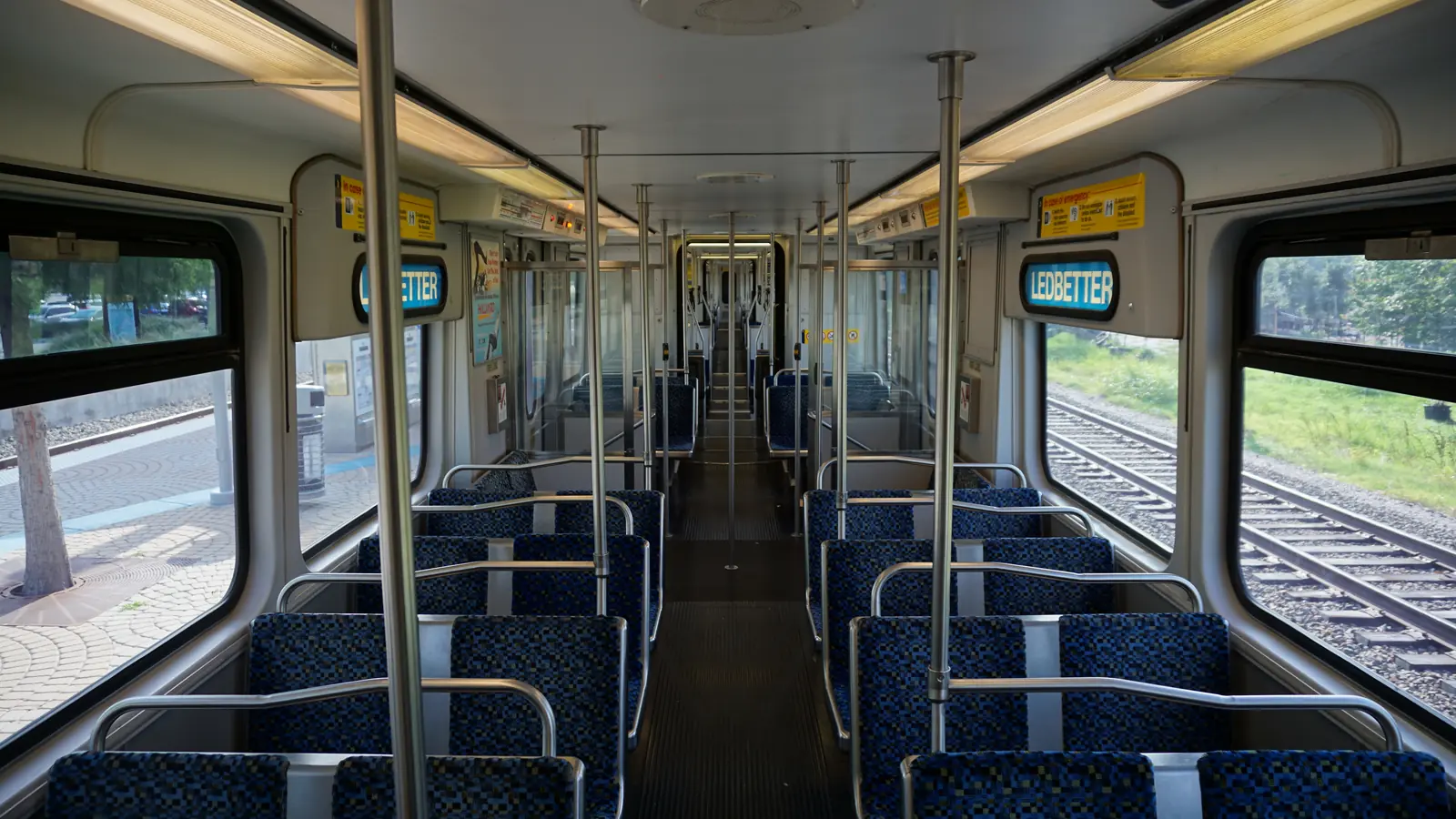 DART light rail vehicle interior with passenger seats, vertical poles and a central aisle