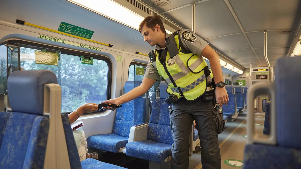 Metrolinx officer checks a passenger’s fare payment aboard a GO Transit train