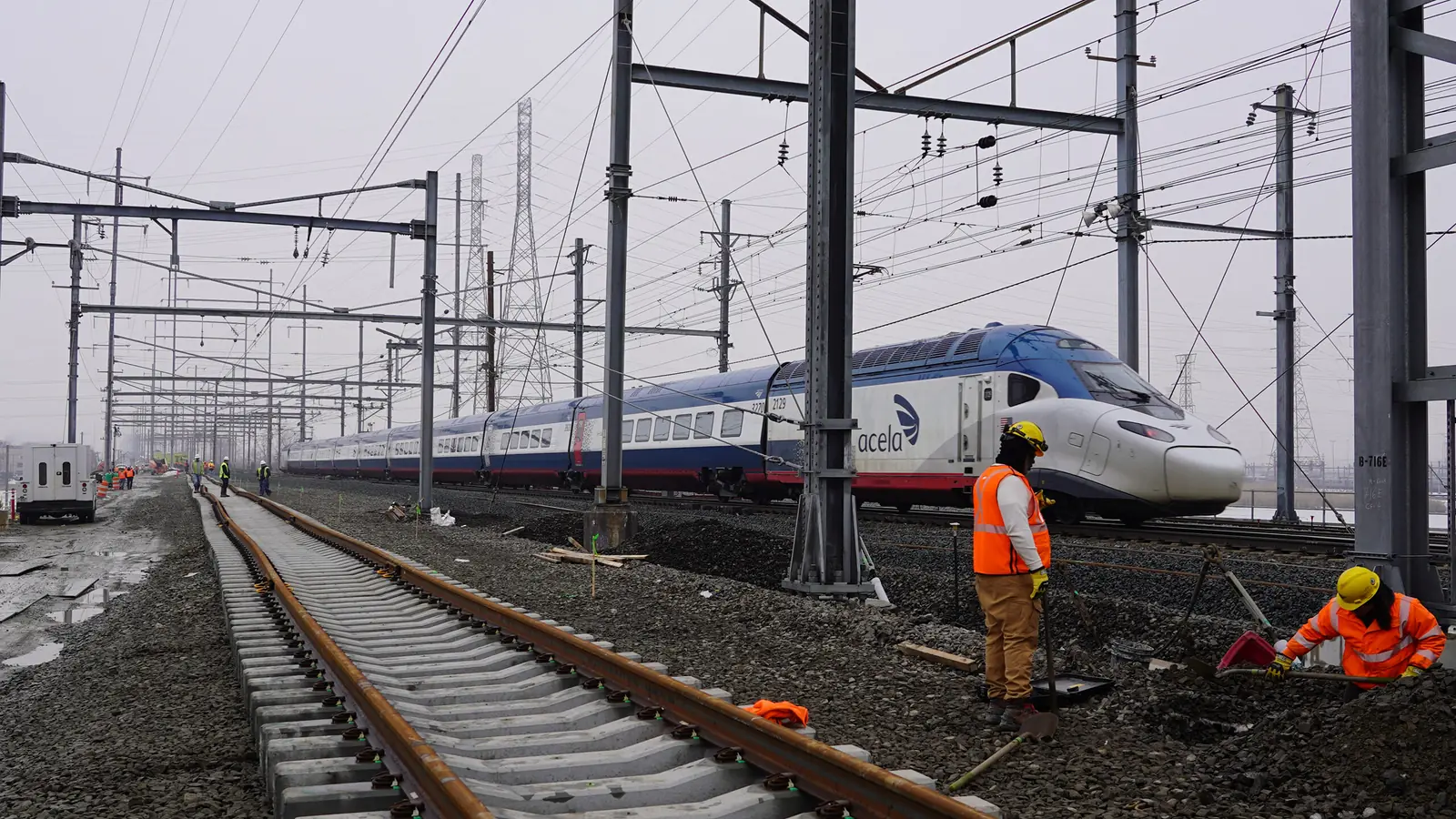 Amtrak Acela beside track crews during Portal North Bridge cutover work