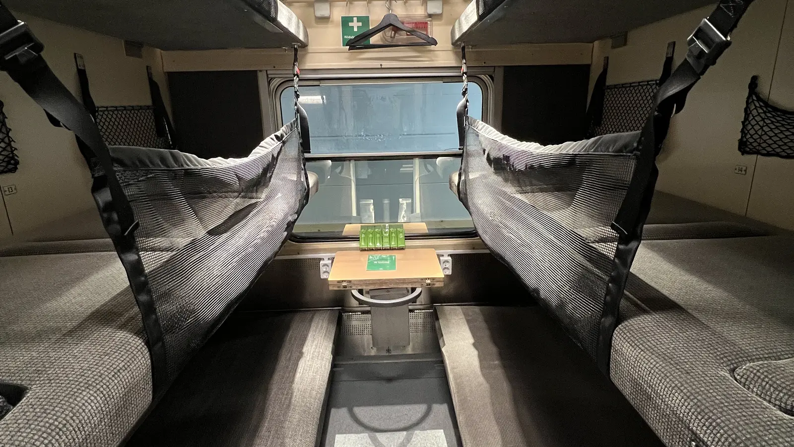 Refurbished SJ six-berth couchette compartment with safety nets and a central table