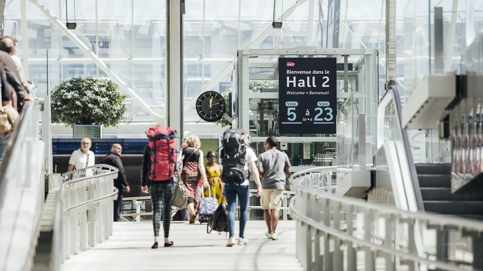 Travellers with backpacks walking through Hall 2 at Paris-Gare-de-Lyon