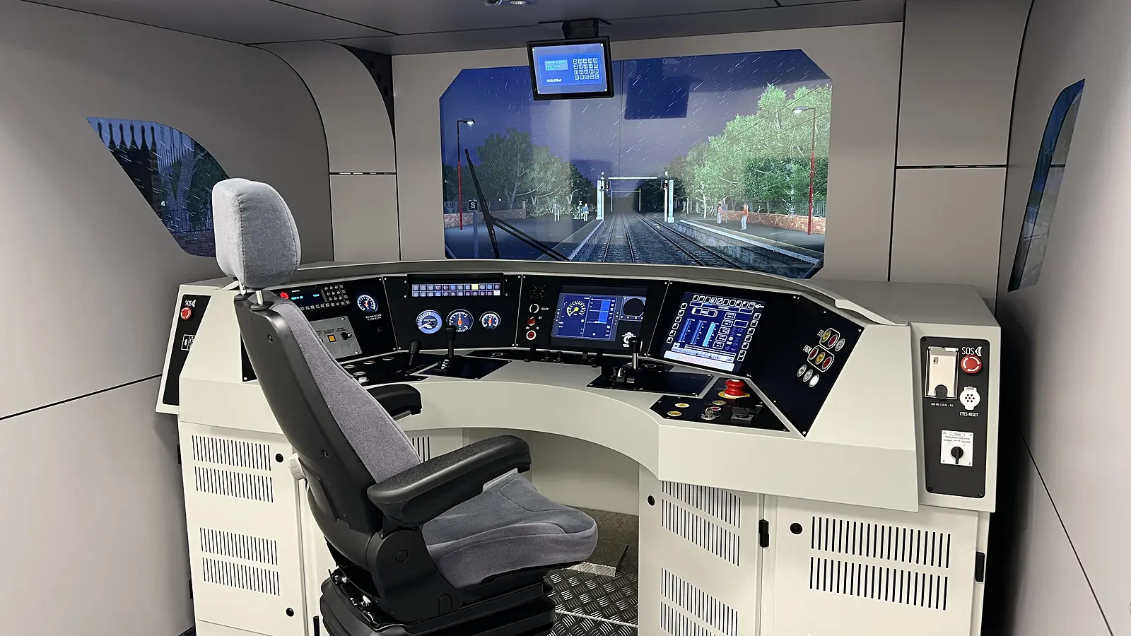 Class 68 ETCS replica simulator cab with a driver’s seat, controls and a projected railway scene