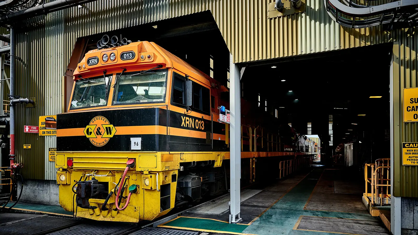 XRN013 locomotive standing at the entrance to a rail maintenance facility