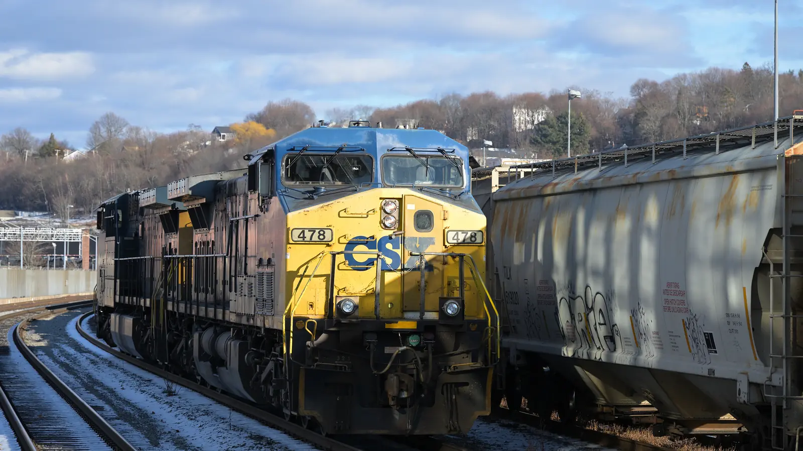CSX locomotive 478 beside covered hopper cars on parallel tracks