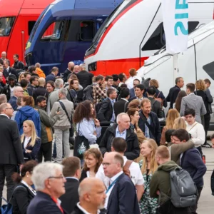 Visitors gather among passenger trains at the InnoTrans outdoor display