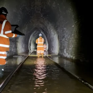 Network Rail engineers inspecting flooded track inside Bransty Tunnel