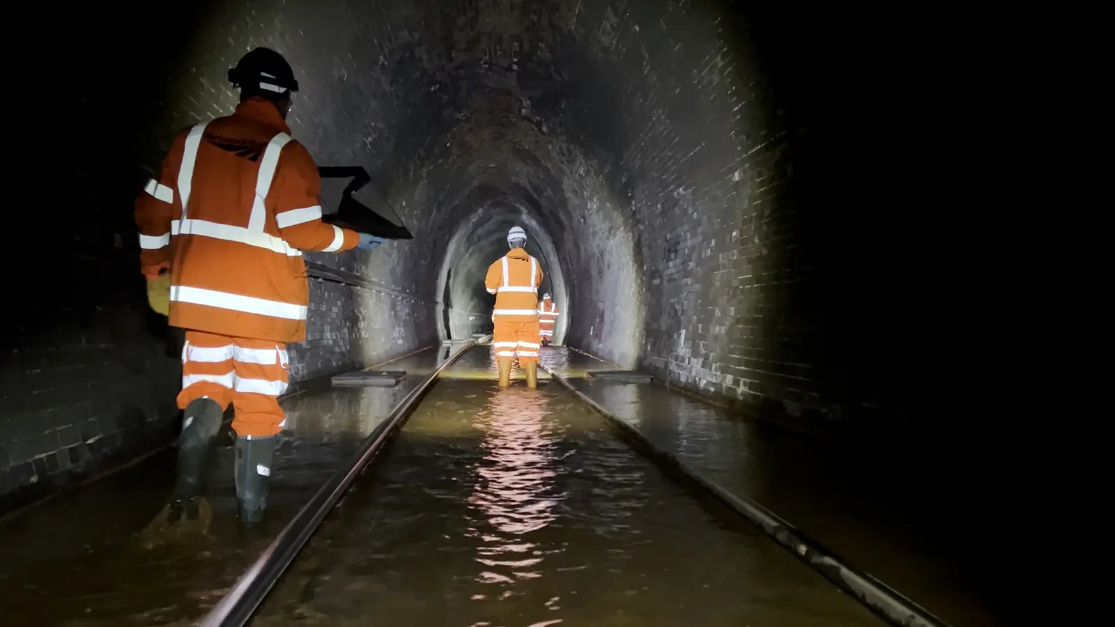 Network Rail engineers inspecting flooded track inside Bransty Tunnel