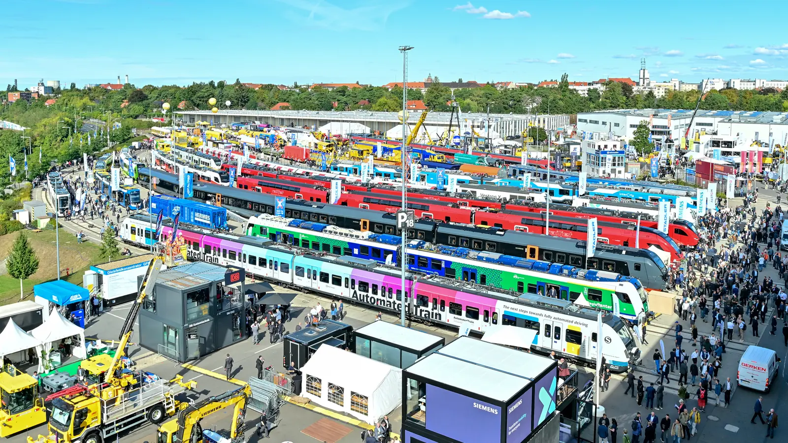 InnoTrans outdoor display with trains, rail equipment and visitors in Berlin